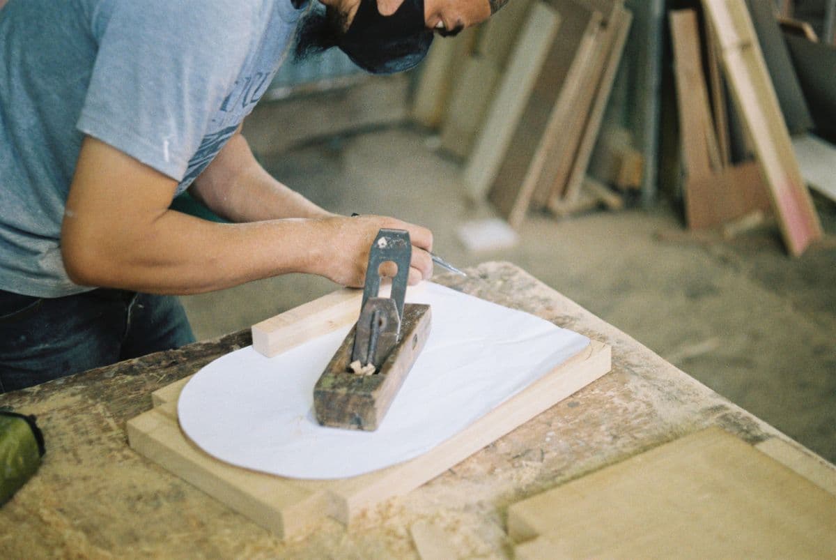 Tischler bearbeitet Holz mit dem Handhobel